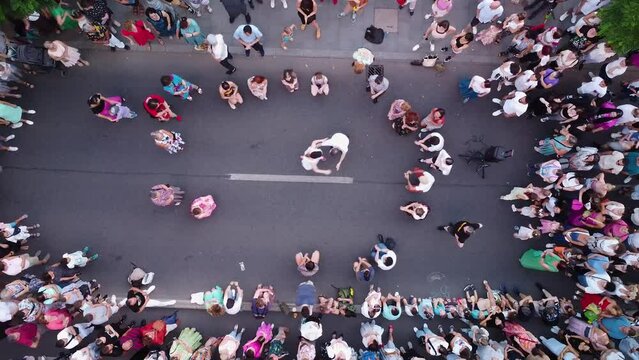 Top down aerial drone footage of people swing dancing in the streets. Noaptea Dansului - The night of the dances. Flash mob dancing swing dances.

