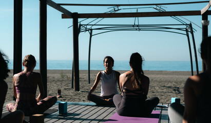 yoga teacher teaching a class at the beach