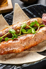 Turkish cuisine. Grilled beef sausages lie on a plate with pita bread and pickled onions