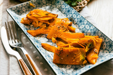 Pumpkin cut into slices and baked with rosemary and extra virgin olive oil - 656376890
