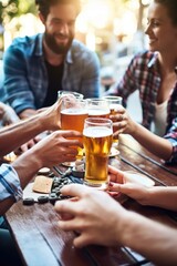 cropped shot of a group of friends having beers at a table outside