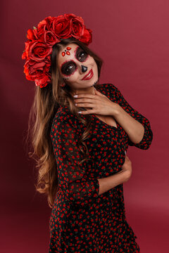 Portrait of scary woman with halloween makeup. Pretty female model posing in mexican attire in day of the dead.