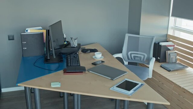 No people shot of empty directors office with laptop, notebooks, tablet, phone, paper folders lying on table