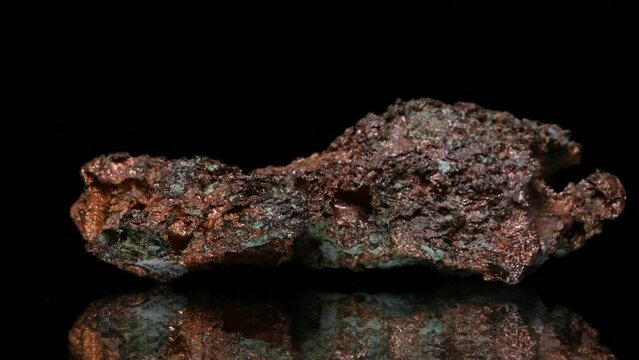 Native copper (copper metal naturally occurring in almost pure form rather than as an ore) sample rotating slowly against a black background.