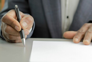 business man writing with pen on a office table with grey background with people stock image stock...