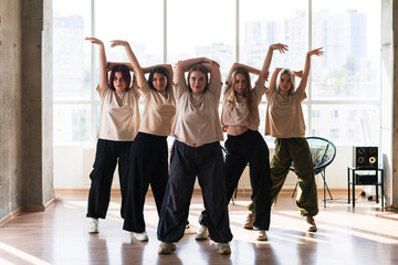 female dancers crew doing synchrone moves in the dance studio