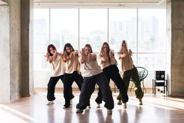 female dancers crew doing synchrone moves in the dance studio