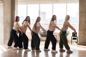 female dancers crew doing synchrone moves in the dance studio