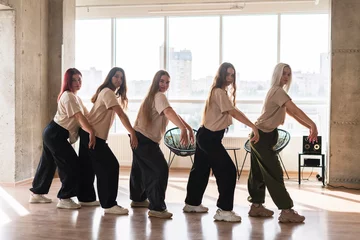 Gordijnen female dancers crew doing synchrone moves in the dance studio © Mihail