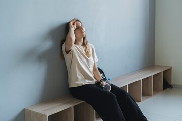female dancer in the locker room drinks water after practice session