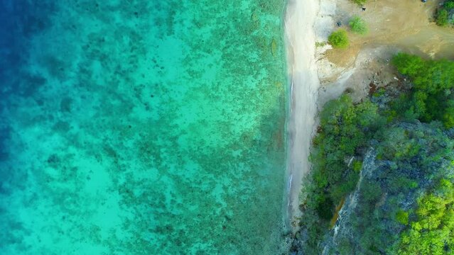 Drone top down pan across clear ocean water reef of San Juan Curacao, relaxing view
