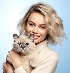 Beautiful young woman with a cat in her arms. Blue background.