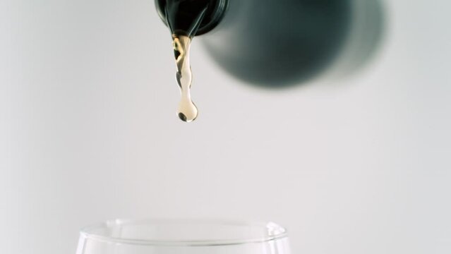 Super Slow Motion Shot of Camera Following White Wine Stream from Bottle into Glass at 1000fps.