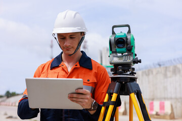 Engineer use theodolite equipment and looking blueprints on tablet construction project for route...