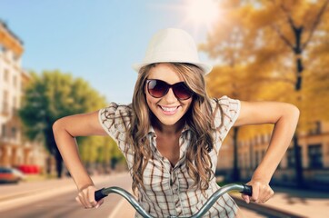 Happy young woman ride on bicycle outdoor.