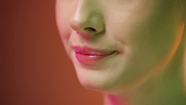 Zmysłowe zbliżenie kobiecych ust kończących picie napoju z pianką i oblizujących wargi z uśmiechem na pomarańczowym tle &mdash; slow motion 4K, smak, styl i kobieca zmysłowość