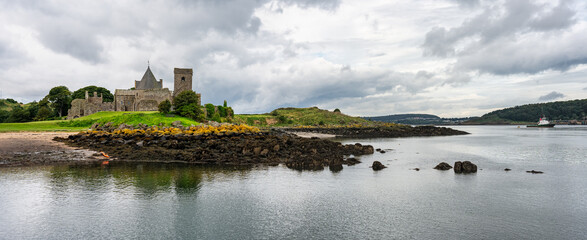 Fototapeta na wymiar Panoramic seascape with a small island that houses a ruined medieval abbey, Edinburgh, Scotland.
