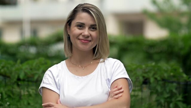 Portrait of a smiling young woman on the background of summer greenery.