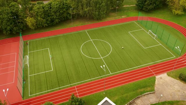 Drone footage of children playing football in a field