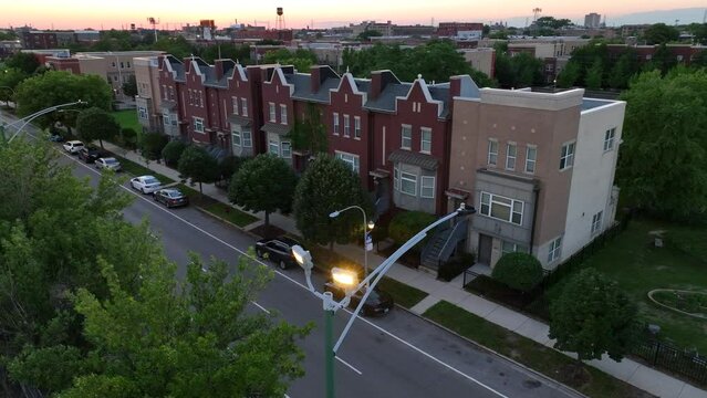 Homes in American city during sunset. Aerial shot of street lights and row houses in urban USA.