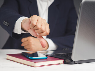 Obraz premium Businessman showing a thumbs down for dislike service while sitting at the table