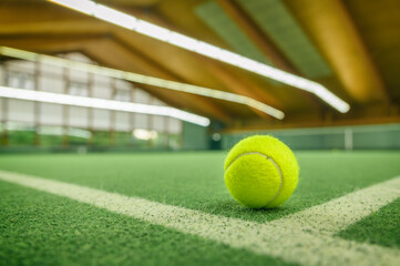 Tennisball liegt auf einem Tennisplatz in einer Tennishalle