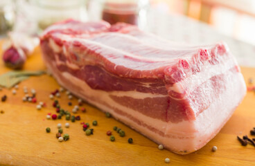 Cooking traditional homemade lard with spices. pork belly with layer on board