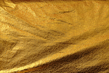 Texture of genuine crumpled leather with wrinkles, golden color, fashion natural background