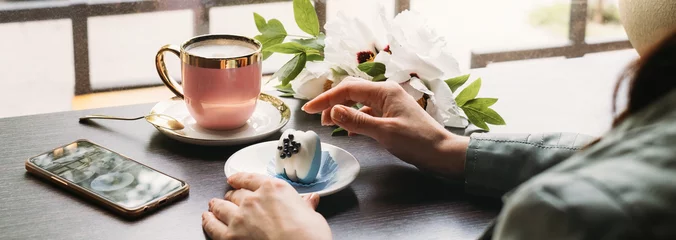 Foto op Aluminium Blue macaroon dessert, original and stylish dessert in cafe in front of window, Hand holding plate with tasty sweet. banner © ninelutsk
