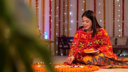 An attractive young woman making a floral rangoli on the occasion of Diwali - festival celebration. Diwali celebration - Indian girl decorating a flower rangoli with white flowers  auspicious occas...