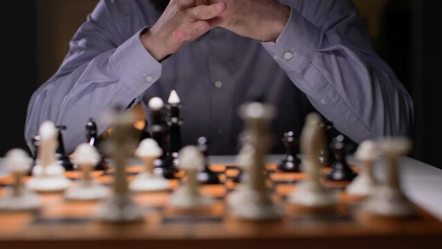 strategy planning, male businessman playing chess and considering next move, close-up