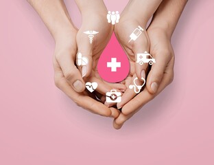 hands holding pink blood drop, donor day concept