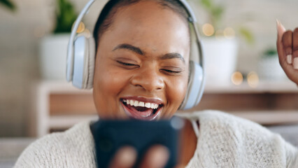 Black woman, headphones and music with smartphone and happiness, audio streaming and fun while at home. Listening to radio, sound and smile for playlist with energy, dancing and mobile app in lounge