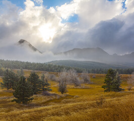 mountain valley in dense mist and clouds at the sunset