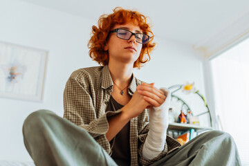 Teen girl with broken arm, wearing glasses, red hair, in bedroom