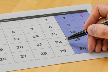 Strona z kalendarza leżąca na biurku, zaznaczać datę dlugopisem