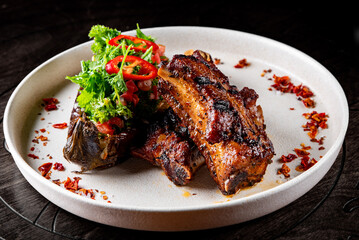grilled pork ribs with baked eggplant on plate