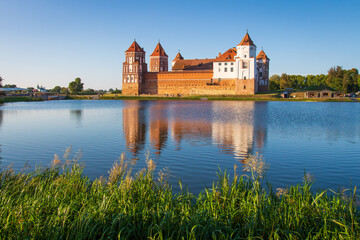 Belarus, Mir. Beautiful view of Mir Castle in late morning. Sunbeams illuminate Castle Complex. Travelling on historical places of Belarus.  - obrazy, fototapety, plakaty