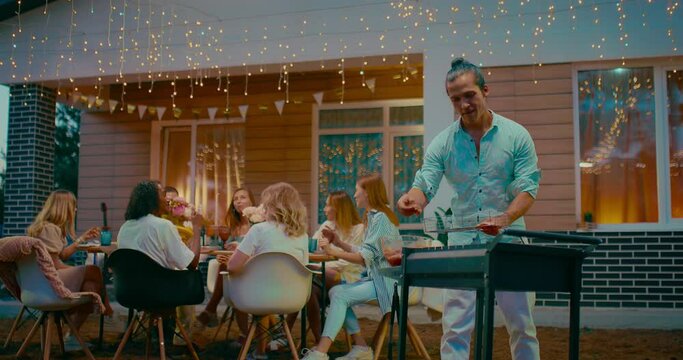 BBQ party in backyard, group of multiethnic young people dinning and chatting in patio, 4K, Prores