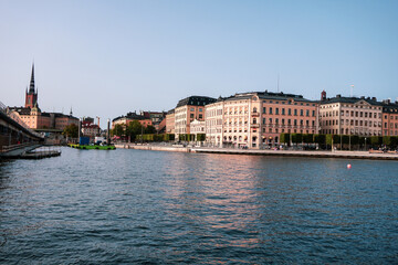 View of buildings by river against clear sky
