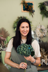 happy woman florist posing at flower shop with hydrangea flower 