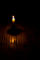a candle in a dark room is on the table, lack of electricity, saving light, no gas and heat