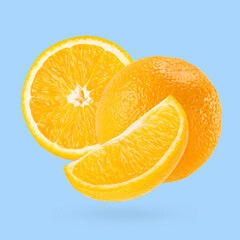 Juicy oranges closeup fly as art composition. Whole, half and quarter piece fruits on pastel blue background with shadow. Summer fruits for advertising, design, label product.