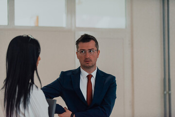 The director conducts a conversation with the secretary and a young programmer in a modern and...