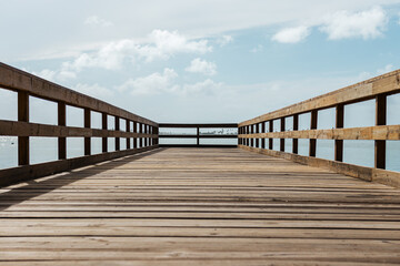 Fototapeta na wymiar perspective of a wooden bridge in a coast with a cloudy sky from puerto rico 