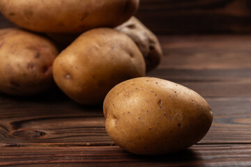 Fresh harvested potatoes on a rough wooden surface
