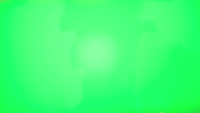 A hand with smartphone near Christmas tree as symbol modern holidays, when online shopping becomes more convenient than ever. Christmas atmosphere and new year approaching. Green screen chromakey