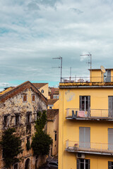 Fototapeta na wymiar Ancient houses on the island of Corfu. Panoramic view of a southern European city. Street landscape in Greece. Vertical photo for social media.