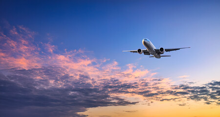 Fototapeta na wymiar Big airplane leaves the ground in the sky at sunset
