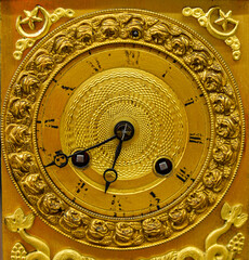 The old clock has a beautiful golden pattern